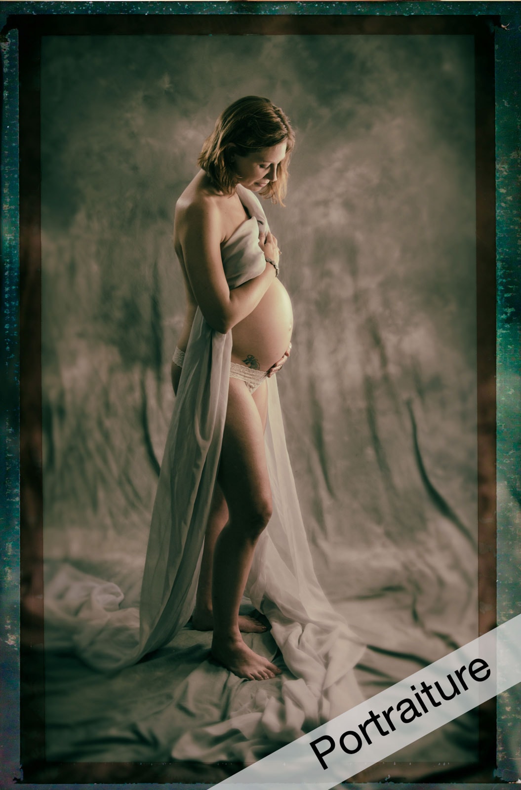 Pregnant woman holding her belly draped in fabric